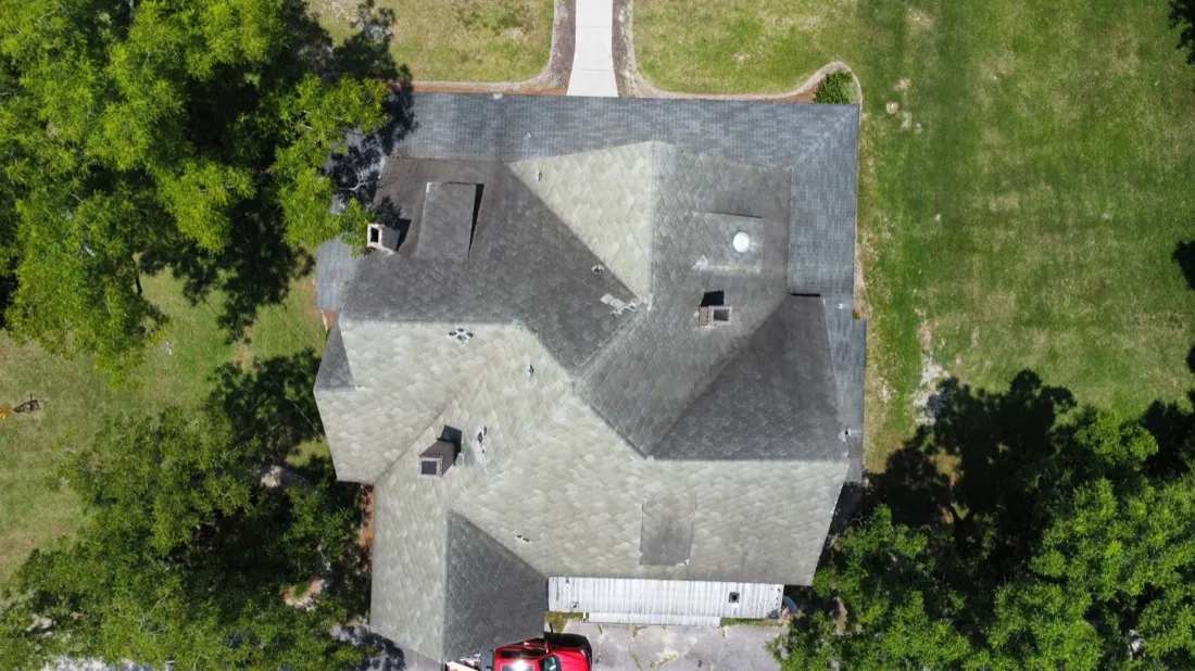 Weathered, algae-streaked shingle roof before replacement