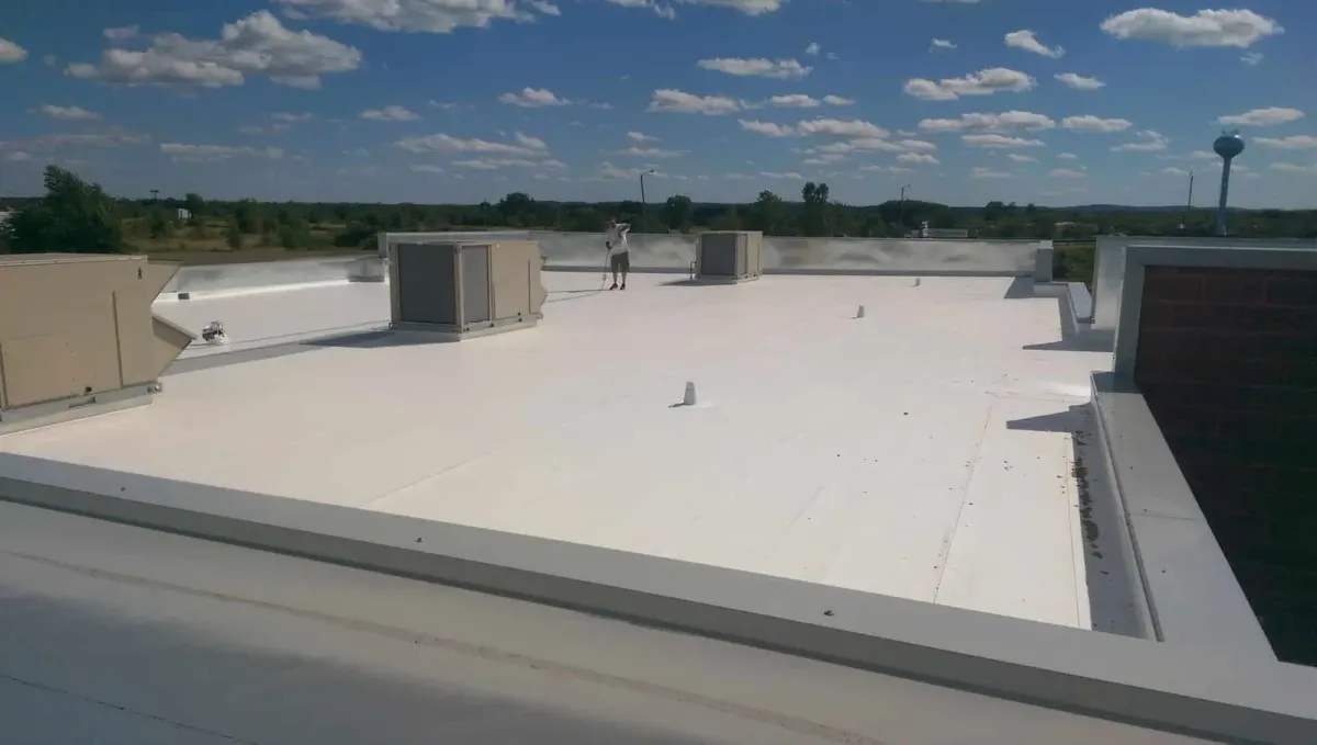 Technician installing a low-slope commercial roofing membrane