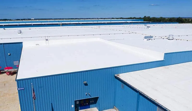 A white membrane roof over a large industrial building